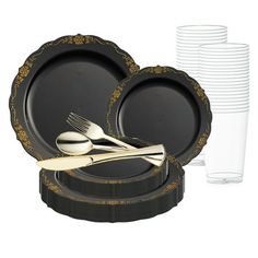 a set of black and gold dinnerware with forks