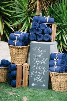 a pile of blue towels sitting on top of a grass covered field next to baskets