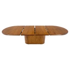 an oval wooden table with four leaves on it