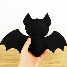 a hand holding a black bat stuffed animal