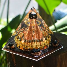 a triangle shaped glass object on top of a wooden post