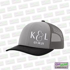 a gray and black trucker hat with the k & l logo in white on it