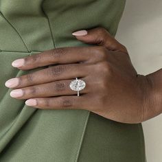 a woman's hand with a ring on her left wrist, wearing a green dress