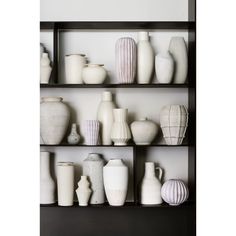 a shelf filled with white vases sitting on top of each other