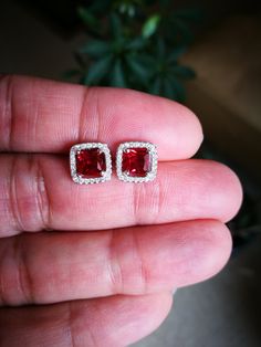 These Halo Ruby Diamond Stud Earrings are one of a kind. They look fabulous and beautiful when worn. These pair of Princess cut Red Ruby with Halo of Round shape simulated diamonds is excellent cut, Bright White D Color, and VVS1 Purity. Ideal for wear at the office, an evening out for dinner or a celebration of birthdays or weddings. It is a sure winner and could be a perfect earring for several occasions and everyday wear. These Earrings feature push backs for secure locking. Comes with a perf Princess Cut Earrings, Red Ruby Earrings, Sliver Earrings, Studs For Men, Halo Diamond Earrings, Ruby Earrings Studs, Halo Earrings, Gold Jewelry Simple, Halo Earrings Studs