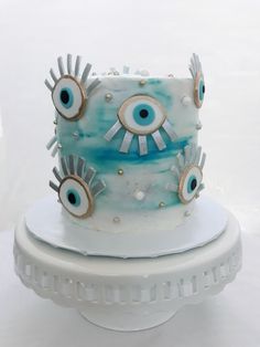 a blue and white cake with evil eyes on it