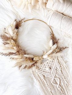 a wreath made out of feathers on top of a white fur covered bedding area