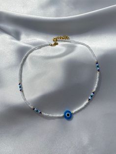 Nazar Evil Eye Choker with white and blue rocailles pearls. 💙 Quantity: 1x Nazar Evil Eye Chocker Size: Beads: 2-3 mm, Nazar Evil Eye: 10 mm If you have any further questions, please do not hesitate to contact me by message or even via Instagram (@boncuk.dream). Thank you and stay healthy! White Evil Eye Beaded Necklace, Evil Eye Bracelet Beads, Beaded Evil Eye Bracelet, Evil Eye Bead Bracelet, Handmade Adjustable White Beads, Handmade White Beads For Gift, Adjustable White Beaded Necklace With Evil Eye, White Small Beads For Jewelry Making, White Tiny Beads For Jewelry Making