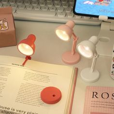 an open book sitting on top of a desk next to a lamp