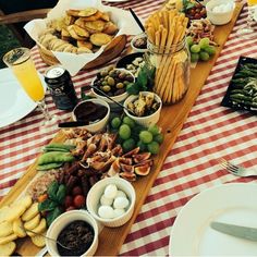 a table topped with lots of food on top of a red and white checkered table cloth