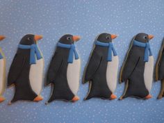 five decorated cookies in the shape of penguins