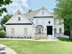 a large white house with black trim on the front