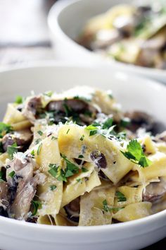 pasta with mushrooms and parmesan cheese in a white bowl