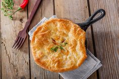 a close up of a pie on a napkin with a fork and knife next to it