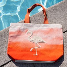 You'll be beach ready with the Maui Water Resistant Tote! Water resistant so your belongings won't get wet, this tote bag features a vibrant coral color with a gorgeous flamingo hand embroidered across the front and inner pockets inside for extra organization, this water resistant bag will be your new summertime staple. This beach bag effortlessly doubles as a cruise bag, sports bag, or overnight bag to store your travel essentials. The perfect vacation bag or "weekend vibes'' bag! This reusable Vacation Bag, Beach Tote Bag, Us Beaches, Beach Ready, Weekend Vibes, Beach Tote Bags, Beach Tote, Overnight Bag, Coral Color