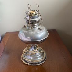 an old fashioned lamp sitting on top of a wooden table