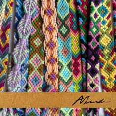 several rows of colorful crocheted bracelets hanging on a wooden hanger with the words alpaca written below them