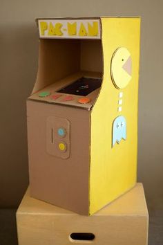 a cardboard box shaped like a pacman machine with an arcade game in the front