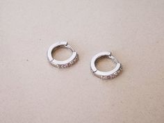 "Pair of ear cuffs / small hoop earrings made of sterling silver and cubic zirconia crystals. HOW YOU CAN WEAR IT? ❖ earlobe earrings DIMENSIONS ❖ inner diameter: 0.35\" (9mm) ❖ length: 0.45\" (11mm) ❖ width: 0.5\" (12mm) MATERIAL ❖ 925 sterling silver ❖ cubic zirconia crystals DO YOU LIKE THIS TYPE OF JEWELRY? Here you can find similar jewelry: https://www.etsy.com/shop/AnairdnaJewelry?section_id=30428461 FOR MORE INFORMATION PLEASE READ FAQ SECTION BELLOW" Silver Huggie Clip-on Hoop Earrings, Silver Huggie Hoop Earrings Clip-on, Silver Clip-on Huggie Earrings Small Hoop, Silver Small Hoop Huggie Earrings Clip-on, Silver Hoop Clip-on Huggie Earrings, Silver Clip-on Hoop Huggie Earrings, Earlobe Earrings, Earrings With Crystals, Cubic Zirconia Hoop Earrings