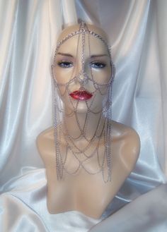 "This silver face chain mask is styled after the character Lady Jessica of the sci fi series Dune. Constructed entirely of silver chain, it lays comfortably on the head and face. The multi layers of chain links allow for graceful movement in its lower front section. It attaches securely in the back with a lobster claw latch for size adjustment. This piece will fit a 20\"- 24 1/2\" head size and can be adjusted in the back for a good fit Lower section of chain links drop to 9\" All items are made Cleopatra Headpiece, Chain Headdress, Lady Jessica, Face Chain, Chain Mask, Graceful Movement, Sci Fi Series, Chain Links, Costume Hats