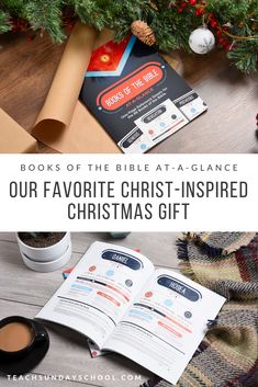 an open book on top of a wooden table next to a christmas tree