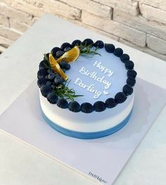 a blue and white birthday cake with an orange slice