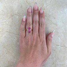 This gorgeous ring features a 1.92 carat oval-cut pink tourmaline ring that is set in prongs. Flanking either side of the stone are two oval-cut diamonds weighing approximately 0.11 carats. Additional prong-set rubies and spinel form a halo around the center stone. The total weight of the spinel is approximately 0.11 carats and the total weight of the rubies is approximately 0.25 carats. This ring is handcrafted in 18k yellow gold.
The measurements of the center tourmaline are 9.34mm x 6.53mm x Luxury Pink Oval Sapphire Ring, Gia Certified Oval Pink Ruby Ring, Gia Certified Oval Pink Diamond Ring, Oval Pink Gia Certified Diamond Ring, Luxury Pink Oval Diamond Ring, Pink Cushion Cut Morganite Jewelry, Luxury Pink Marquise Ring, Pink Round Cut Tourmaline Jewelry, Pink Oval Ruby Ring With Center Stone