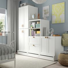 a bedroom with blue walls and white furniture