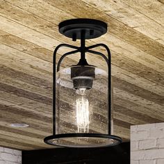 a light fixture hanging from the ceiling in a room with wood paneled walls and ceilings