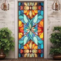 a colorful stained glass door with potted plants on the side and two hanging lights