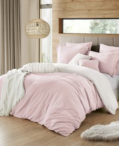 a bed with pink and white comforters in a bedroom