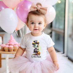 a baby girl wearing a t - shirt and tutu with a cat on it