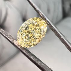 a yellow diamond sitting on top of a metal bar