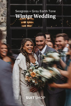 a bride and groom standing in front of a building with their wedding party behind them