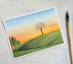 a watercolor painting of a tree on a hill with a sunset in the background