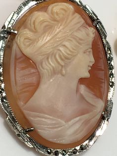 "Handmade Brooch with hand carved depiction of a Victorian woman in a conch shell cameo. The frame of the cameo has Marcasite set and surrounding it. The Handmade silver frame is made with hand-carved design. The Silver Pin Stick and lock are in perfect working order and condition as is the silver bale on the top so that it can be worn as a pendant. The Marvella Pearls are in the length of 21.5\", each pearl is separately hand-tied." Carved Brooches For Formal Occasions, Sterling Silver Hallmarked Brooches, Formal Engraved Brooches, Victorian Women, Cameo Brooch, Silver Pin, Conch Shell, Star Jewelry, Brooches Handmade