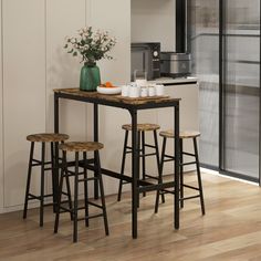 a kitchen table with three stools next to it