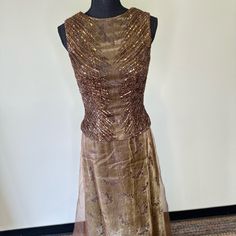 a dress that is on a mannequin with gold sequins and beads