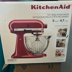 a red kitchen aid mixer sitting on top of a cardboard box with instructions for how to use it