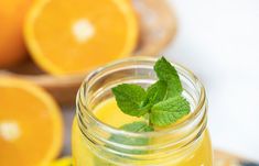 a glass jar filled with liquid next to sliced oranges