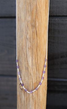 This hand strung necklace is made with Sterling Liquid silver and Amethyst. This is a single strand necklace. There are Liquid silver beads strung and nine small round purple Amethyst beads in between. This is a gorgeous necklace that has a barrel clasp.  16"  Amethyst (3mm) Barrel Clasp 4 Grams Adjustable Single Strand Lavender Beaded Necklace, Adjustable Lavender Single Strand Beaded Necklace, Adjustable Lavender Single Strand Necklace, Sterling Silver Crystal Necklace With Silver Beads For Gift, Gift Sterling Silver Crystal Necklace With Silver Beads, Lavender Jewelry With Tiny Beads For Gifts, Spiritual Single Strand Sterling Silver Necklace, Spiritual Single Strand Sterling Silver Beaded Necklaces, Spiritual Sterling Silver Single Strand Necklace