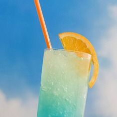 an orange and blue drink sitting on top of a table next to a beach chair