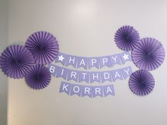 purple paper fans are hanging on the wall with happy birthday korra written in it