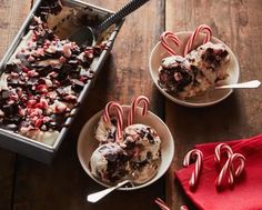 two bowls filled with ice cream and candy canes on top of a wooden table