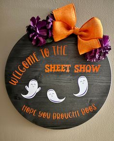 a sign that says welcome to the sheet show and two ghost faces with orange bows