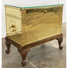 an antique brass chest with glass top on wheels and legs, in the shape of a trunk