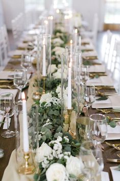 a long table with candles and flowers on it is set up for a formal dinner