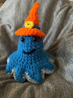 a crocheted blue and orange stuffed animal wearing a hat