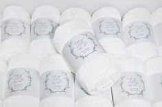 many white towels are laid out together on the floor, with names and date printed on them