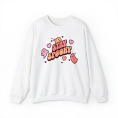 Embrace the Halloween season with our Stay Spooky Retro crewneck! This unique and adorable sweatshirt is perfect for anyone who loves all things spooky and cute. Crafted from high-quality fabric, it's comfortable for everyday wear or as part of your Halloween costume. The retro-style font adds a touch of nostalgia, while the cute ghosts and hearts give it a charming and playful twist. It's the ideal crewneck to show your love for Halloween in a sweet way. Ideal for any situation, a unisex heavy blend crewneck sweatshirt is pure comfort. With a loose fit, these crewnecks run true to size. These garments are made from 50% polyester and 50% cotton. This combination helps designs come out looking fresh and beautiful. The collar is ribbed knit, so it retains its shape even after washing. There Kawaii Letter Print Sweatshirt For Fall, Kawaii Letter Print Tops For Fall, Fall Kawaii Graphic Print Sweatshirt, Fall Kawaii Sweatshirt With Graphic Print, Cute Halloween Sweatshirt With Letter Print, Kawaii Graphic Print Tops For Fall, Kawaii Tops With Graphic Print For Fall, Cute Crew Neck Sweatshirt With Slogan, Cute Slogan Crew Neck Sweatshirt